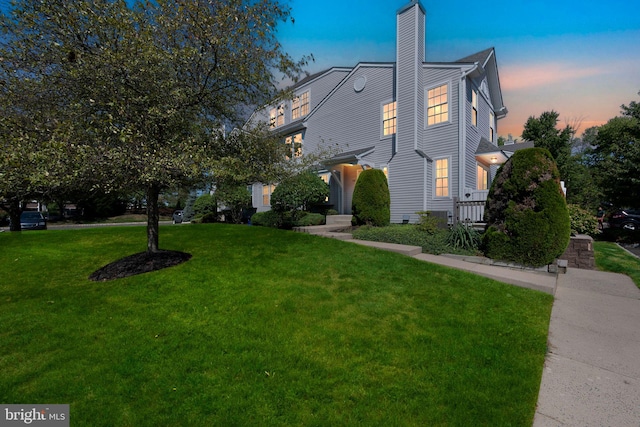 view of front of home with a yard and a chimney