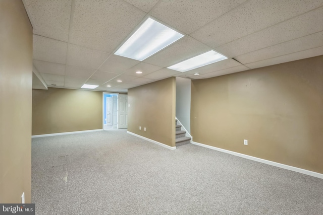 basement with a paneled ceiling and carpet floors