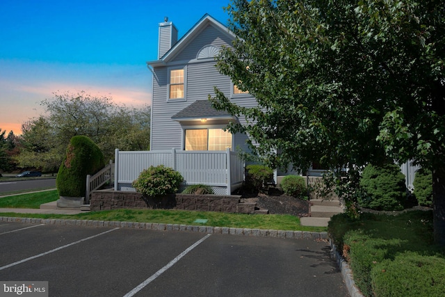 view of front of property featuring uncovered parking and a chimney