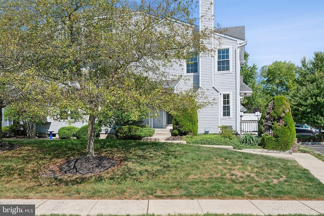 view of front of house featuring a front lawn and a chimney