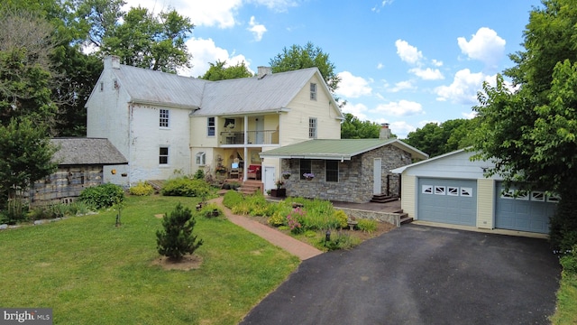 view of front of home with a garage, covered porch, and a front lawn