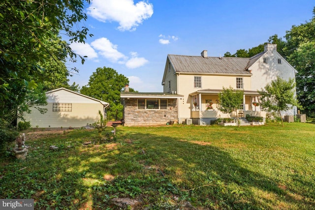 back of house featuring a lawn