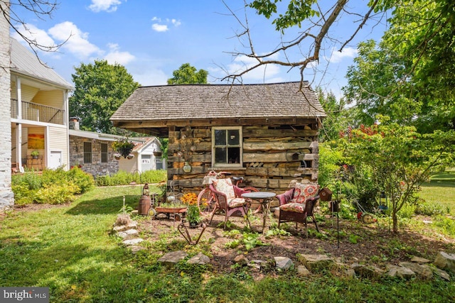 view of outdoor structure featuring a yard and an outdoor fire pit