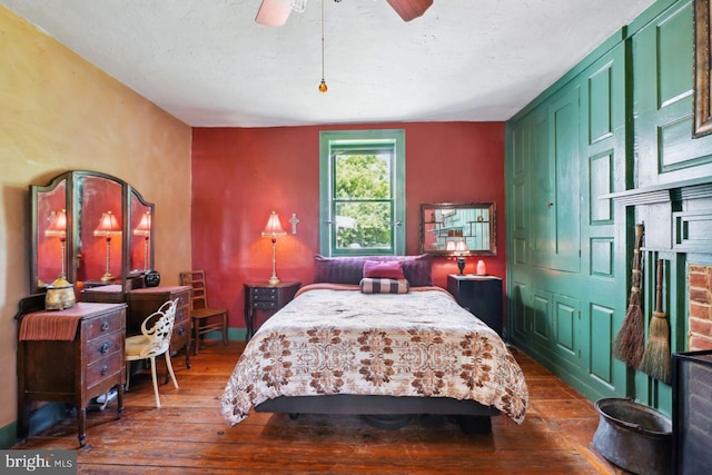 bedroom featuring ceiling fan, dark hardwood / wood-style flooring, and a textured ceiling