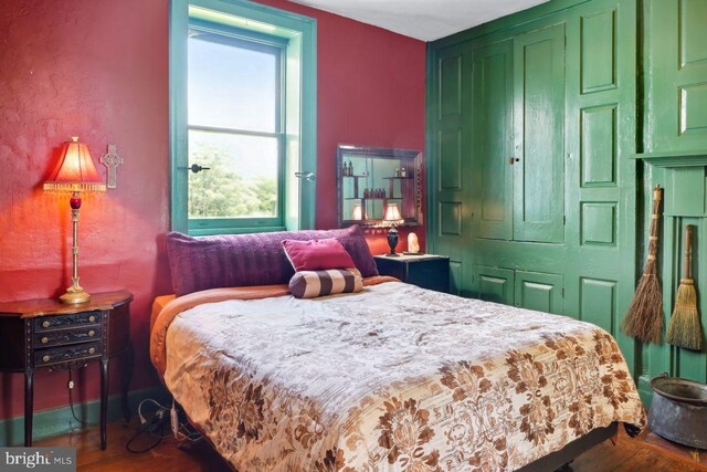 bedroom with dark wood-type flooring