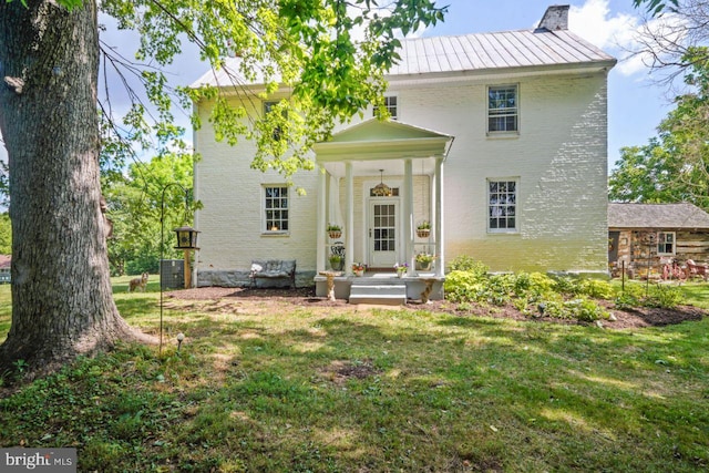 rear view of house featuring a lawn