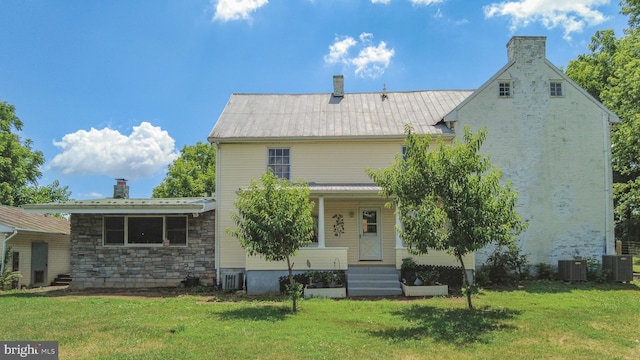 rear view of house with a yard and central AC unit