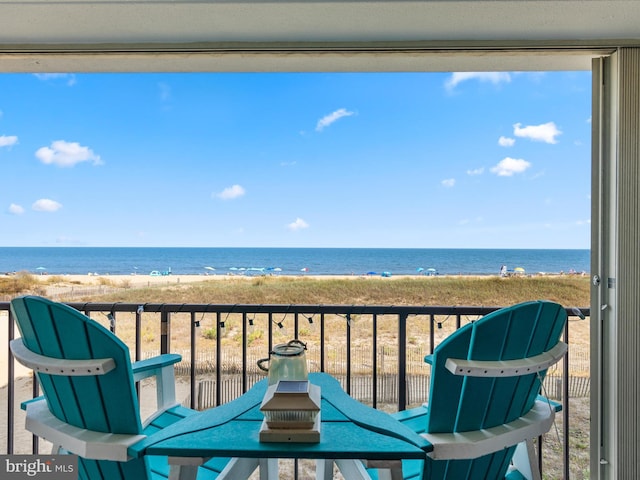 balcony with a water view and a view of the beach