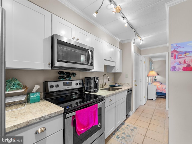 kitchen with stainless steel appliances, white cabinets, a sink, and crown molding