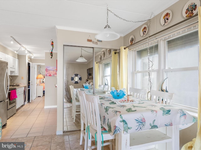 dining area featuring baseboards, ornamental molding, and light tile patterned flooring