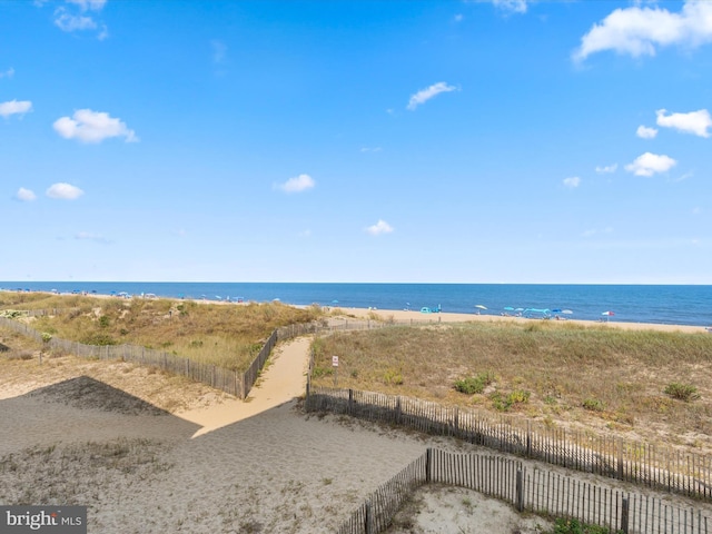 view of water feature with fence and a beach view