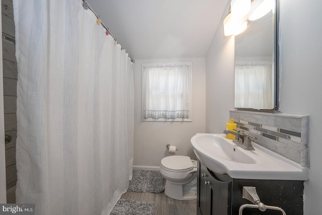 bathroom featuring backsplash, toilet, a shower with curtain, wood-type flooring, and vanity