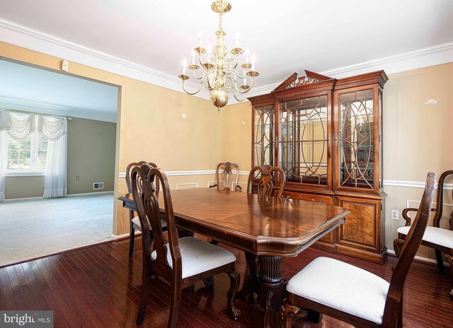 dining area featuring an inviting chandelier, dark hardwood / wood-style flooring, and ornamental molding