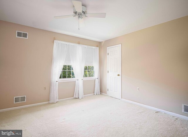 carpeted spare room with ceiling fan