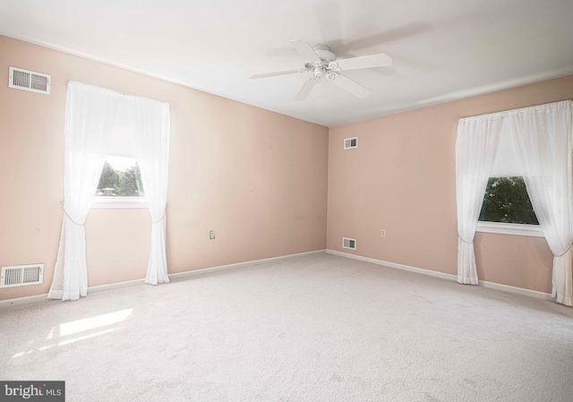 carpeted spare room with ceiling fan