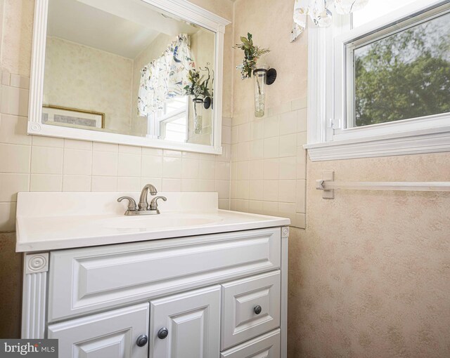 bathroom with vanity, tile walls, and decorative backsplash