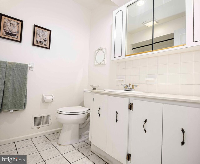 bathroom featuring vanity, toilet, and decorative backsplash