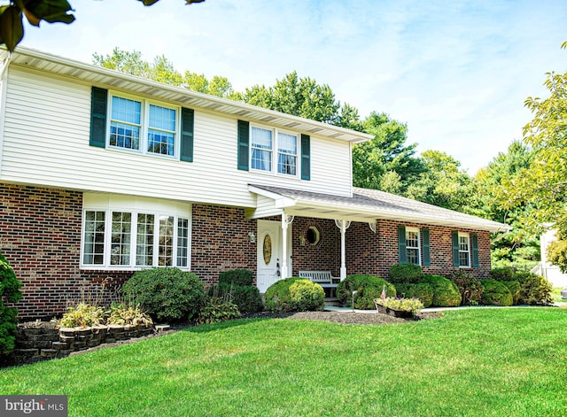 view of front of home with brick siding and a front lawn