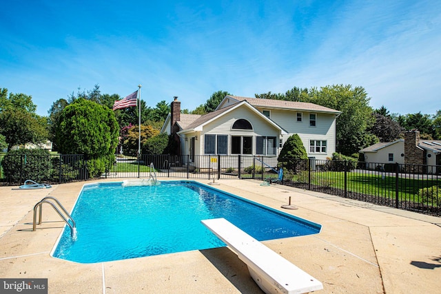 view of swimming pool with a diving board and a patio