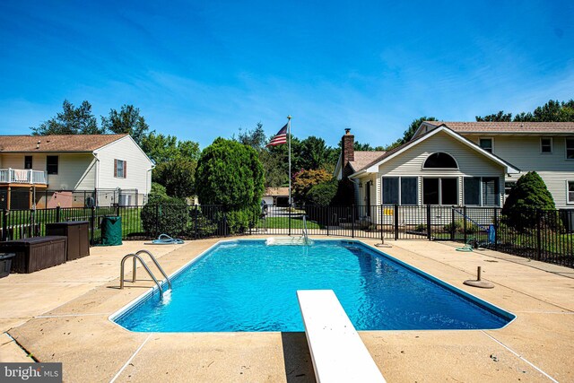 view of pool featuring a diving board and a patio