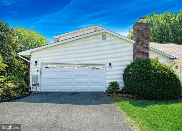 view of home's exterior with a garage and a yard