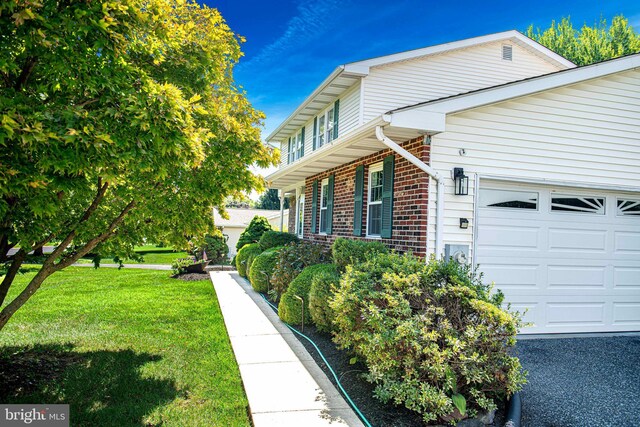 view of property exterior featuring a garage and a lawn