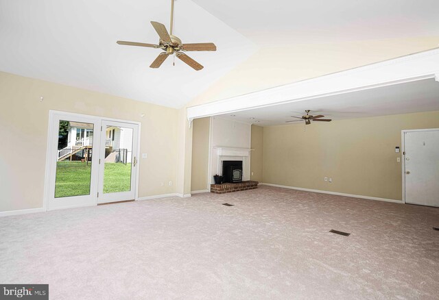 unfurnished living room with high vaulted ceiling, ceiling fan, light colored carpet, and a fireplace