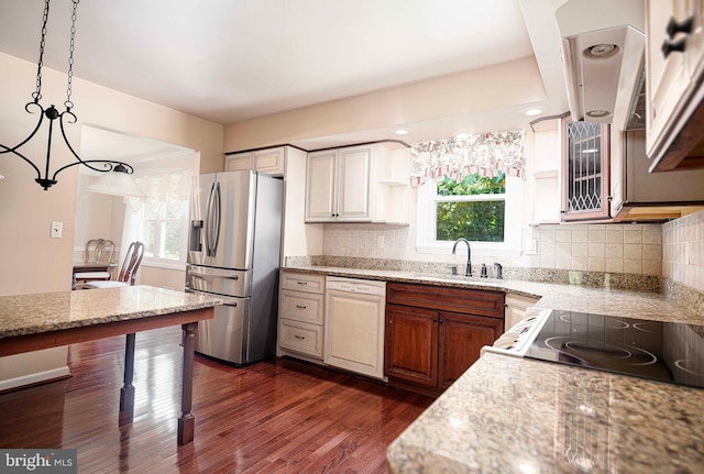 kitchen featuring plenty of natural light, dark hardwood / wood-style floors, decorative light fixtures, and stainless steel fridge with ice dispenser