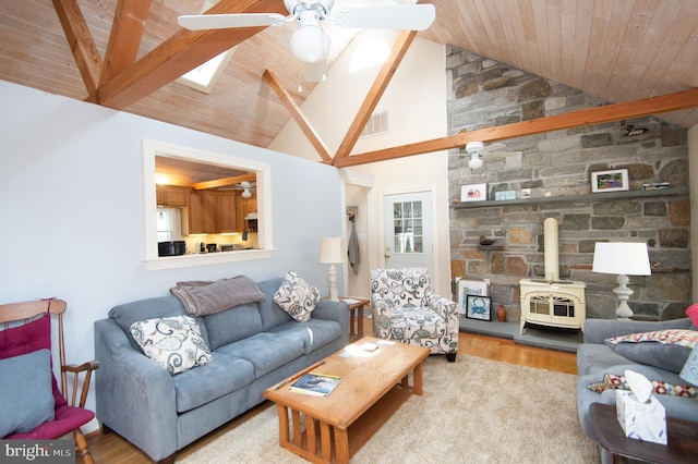 817 Seabreeze Rd, Cambridge, MD 21613 - living area with a wood stove, lofted ceiling with skylight, visible vents, ceiling fan, and wood finished floors