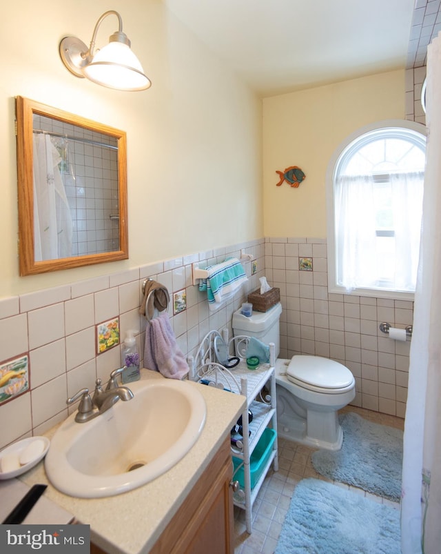 817 Seabreeze Rd, Cambridge, MD 21613 - full bath with tile patterned floors, toilet, vanity, wainscoting, and tile walls