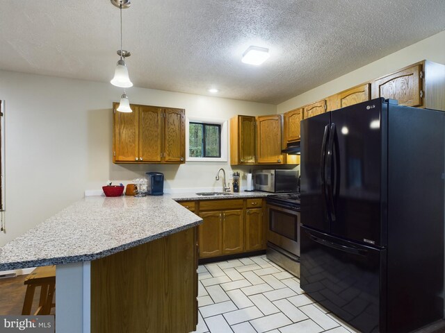 kitchen with decorative light fixtures, black refrigerator, sink, electric range oven, and kitchen peninsula