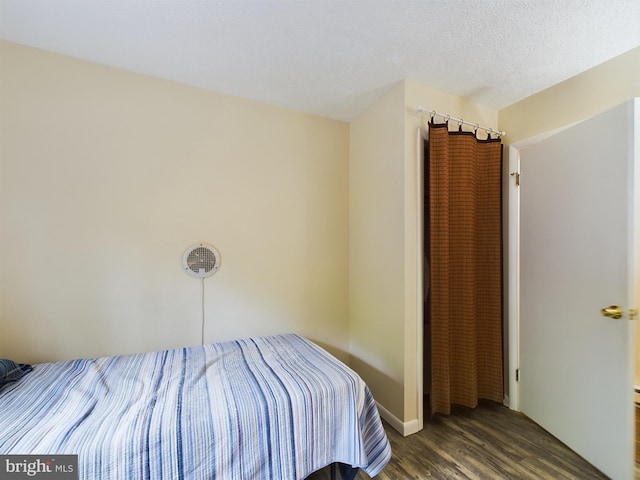 unfurnished bedroom with dark hardwood / wood-style flooring and a textured ceiling