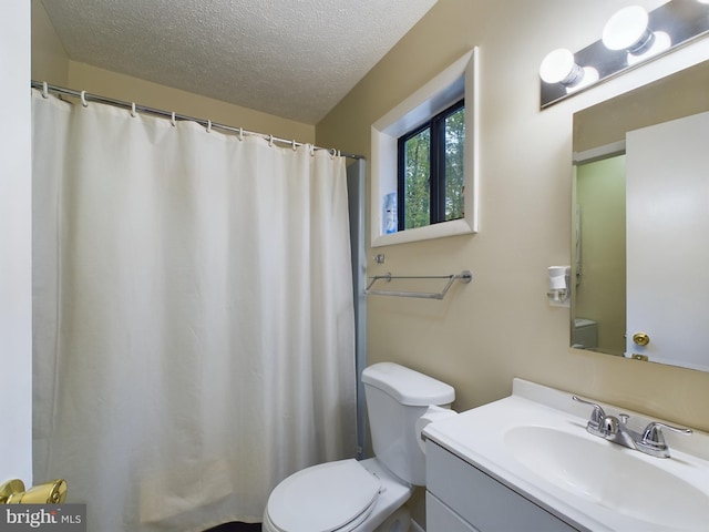 bathroom with vanity, a textured ceiling, and toilet