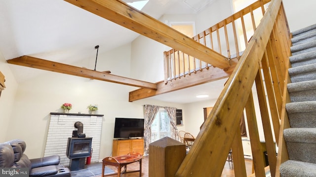 living room with high vaulted ceiling, a wood stove, and a baseboard radiator