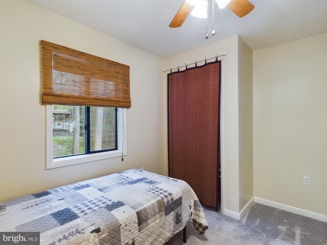 bedroom featuring carpet flooring, a textured ceiling, and ceiling fan