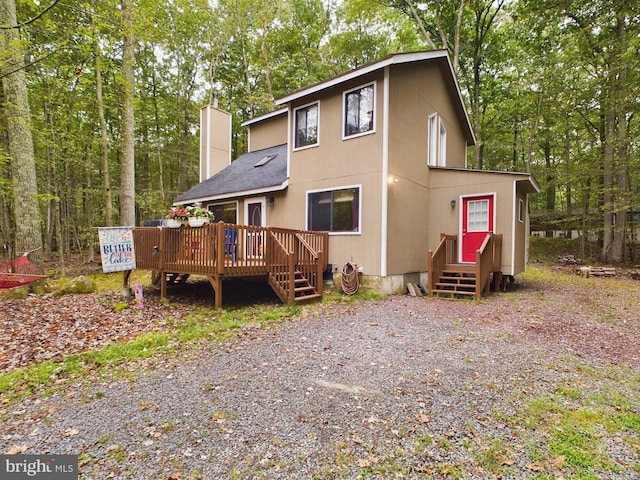 rear view of property featuring a wooden deck