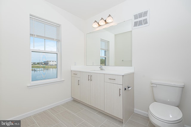 bathroom featuring toilet, baseboards, visible vents, and vanity