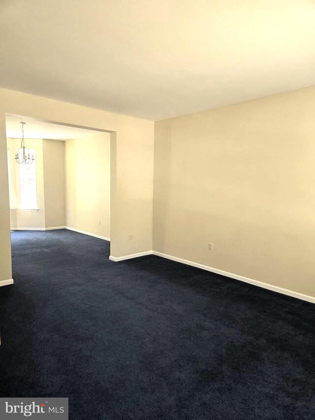 unfurnished room featuring carpet flooring and a chandelier