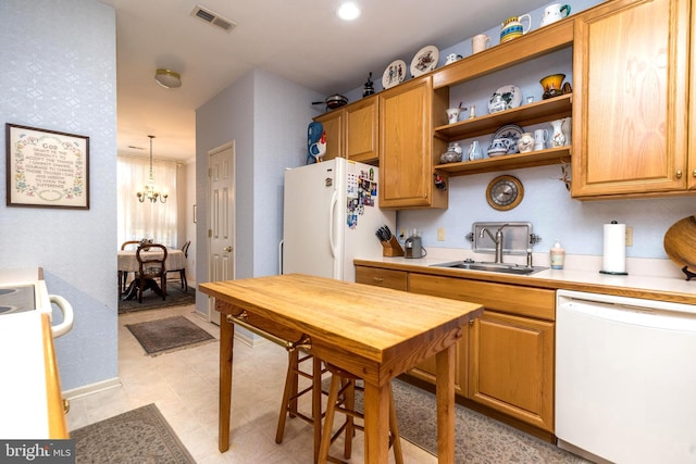 kitchen with pendant lighting, sink, and white appliances