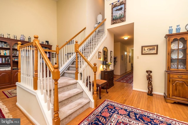 stairway featuring a high ceiling and hardwood / wood-style flooring