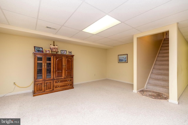 basement featuring light carpet and a paneled ceiling