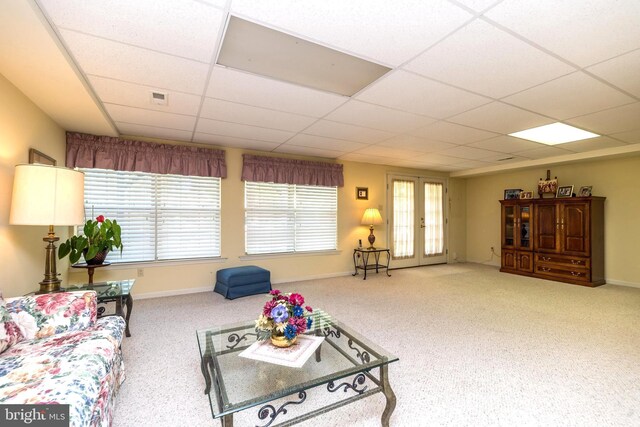 living room featuring carpet floors and a paneled ceiling