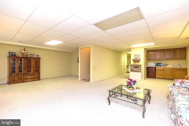 living room featuring light colored carpet and a paneled ceiling