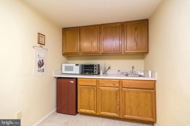 kitchen featuring light colored carpet and sink