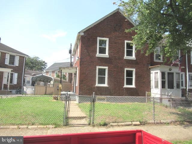 view of side of home featuring a lawn and a sunroom