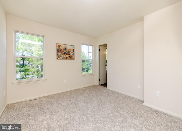 unfurnished room featuring light carpet