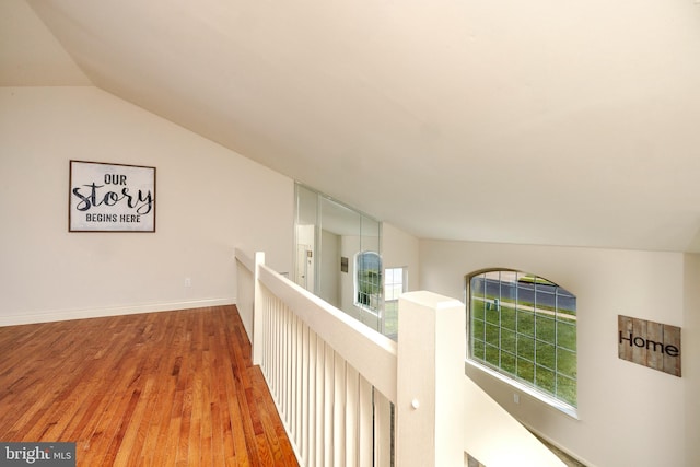 hall featuring lofted ceiling and hardwood / wood-style flooring