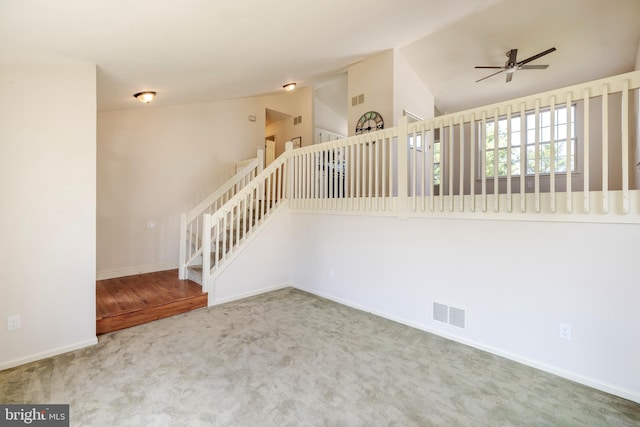 empty room with ceiling fan, carpet floors, and lofted ceiling