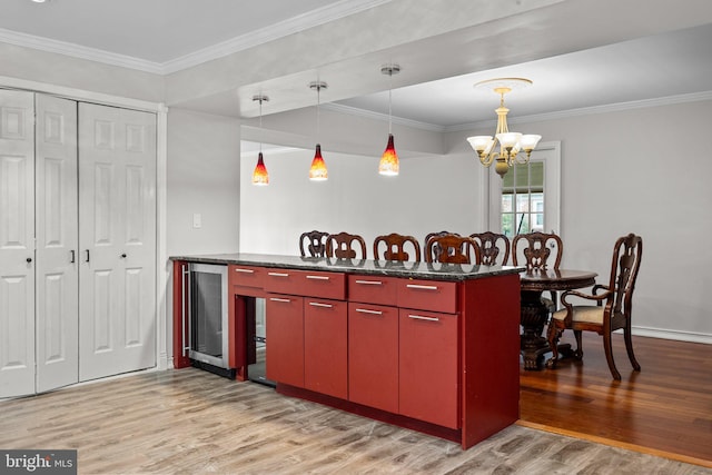 kitchen featuring an inviting chandelier, ornamental molding, wine cooler, and light hardwood / wood-style floors