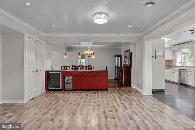 bar with wine cooler, light wood-type flooring, crown molding, and stainless steel dishwasher